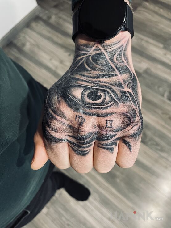 Tattoo Oko na dłoni in black and gray motif and realistic style on the hand