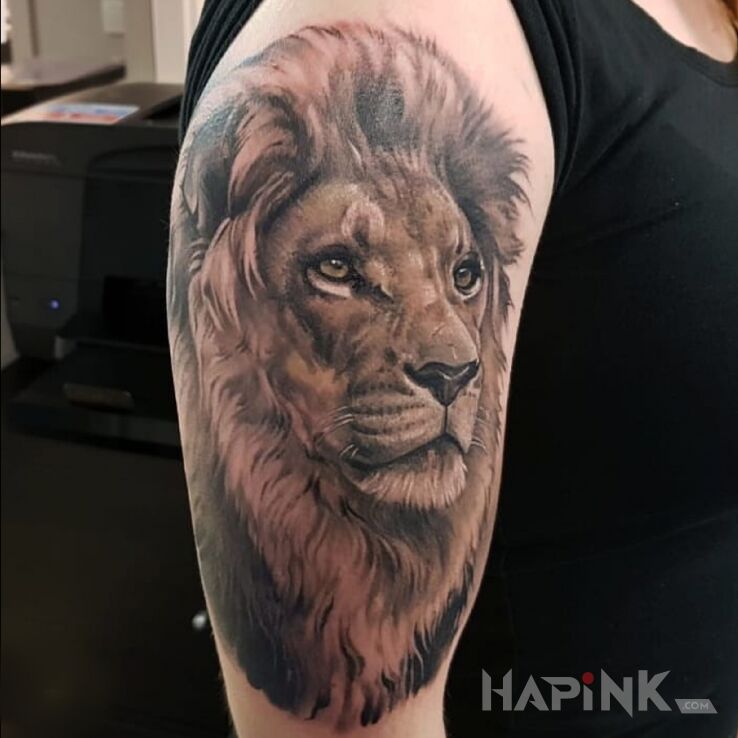 Tattoo Lew in colorful motif and realistic style on the upper arm