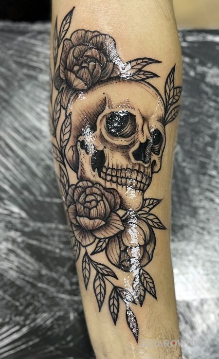 Tatuaż czaszka z kwiatami w motywie czaszki i stylu blackwork / blackout na przedramieniu