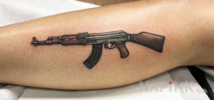Tattoo AK47 in objects motif and realistic style on the leg