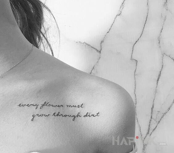 Tattoo Każdy kwiat in lettering motif and calligraphy style on the collarbone