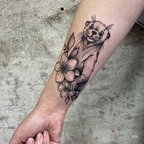 Tattoo Graphic Otter on the forearm motif: black and gray style: graphic / illustrative
