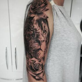 Tattoo Lion On the arm motif: flowers style: realistic