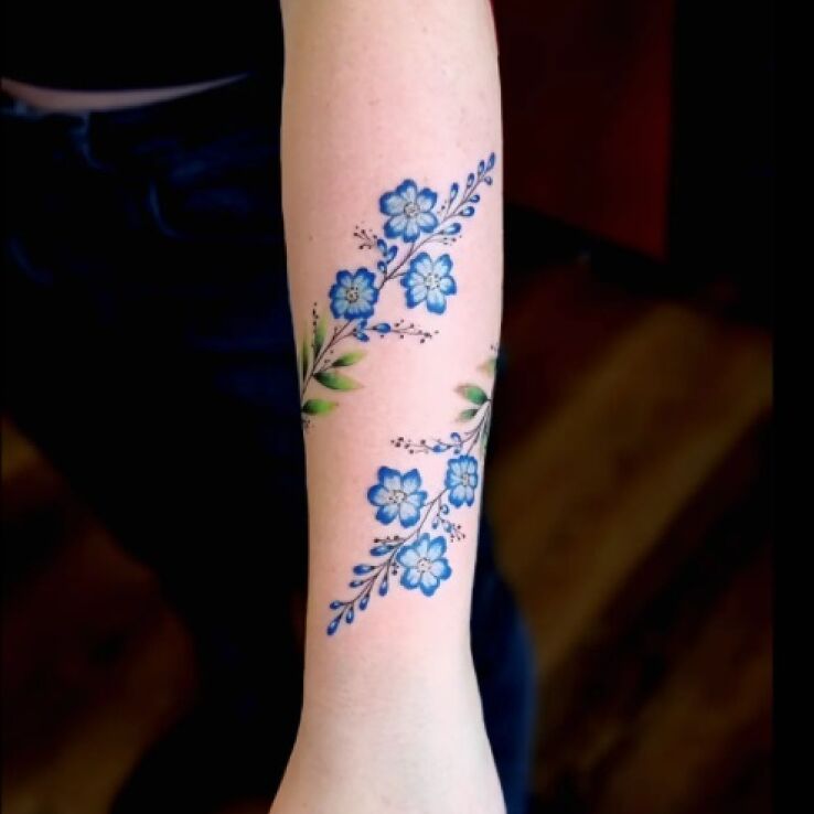 Tatuaż subtelna kwiecista opaska w motywie ornamenty i stylu kontury / linework na przedramieniu