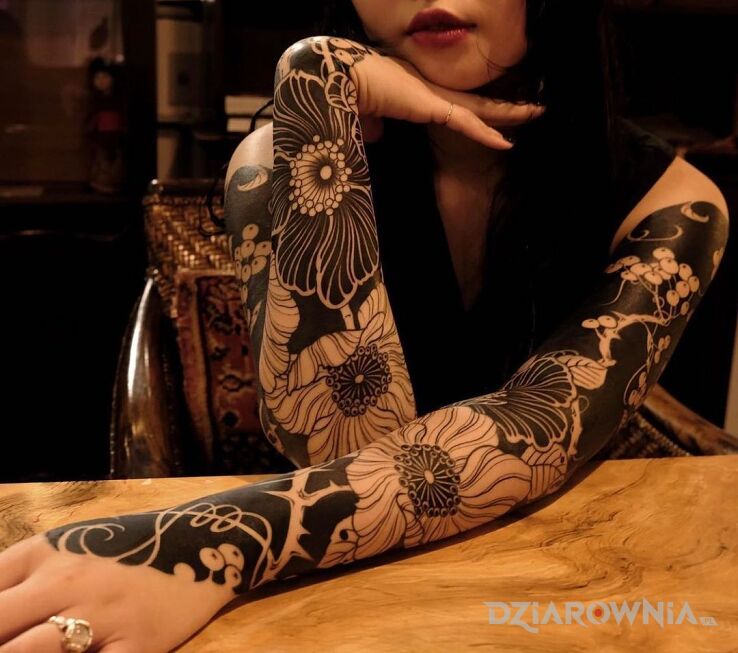 Tatuaż czarne i białe kwiaty w motywie rękawy i stylu blackwork / blackout na ramieniu