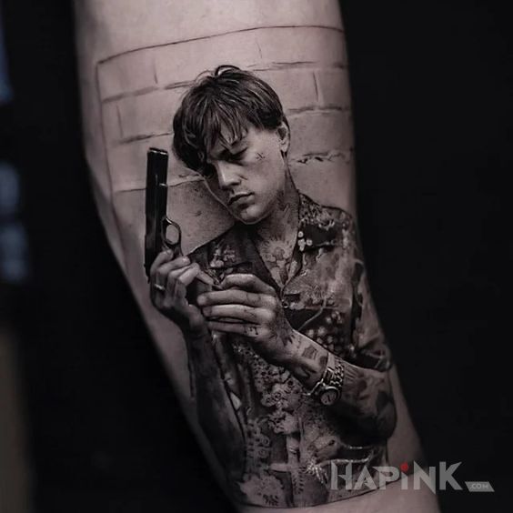 Tattoo Uzbrojony Leo in black and gray motif and realistic style on the leg