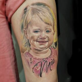 Tattoo Daughter's little portrait on the leg motif: lettering style: realistic