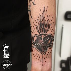 Tattoo Burning heart On the arm motif: black and gray style: graphic / illustrative