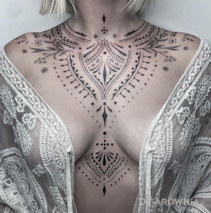 Tatuaż cudeńko w motywie ornamenty i stylu minimalistyczne między piersiami
