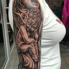 Tattoo Thoughtful angel On the arm motif: religious style: realistic