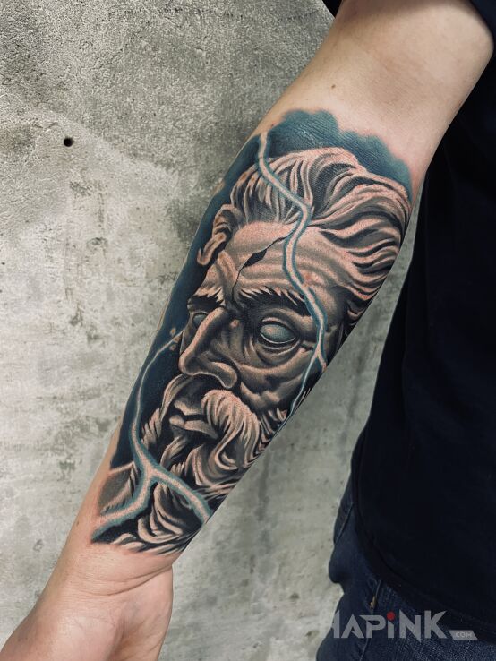 Tattoo Kamienny Zeus in faces motif and realistic style On the arm