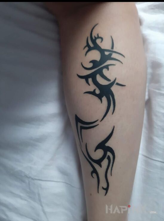Tattoo Tribal in black and gray motif and tribal style on the calf