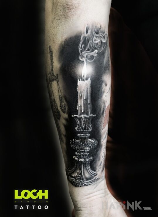 Tattoo Paląca się świeca in black and gray motif and realistic style On the arm