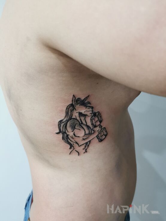 Tattoo Jednorożec na siłowni in fantasy motif and dotwork style on the ribs