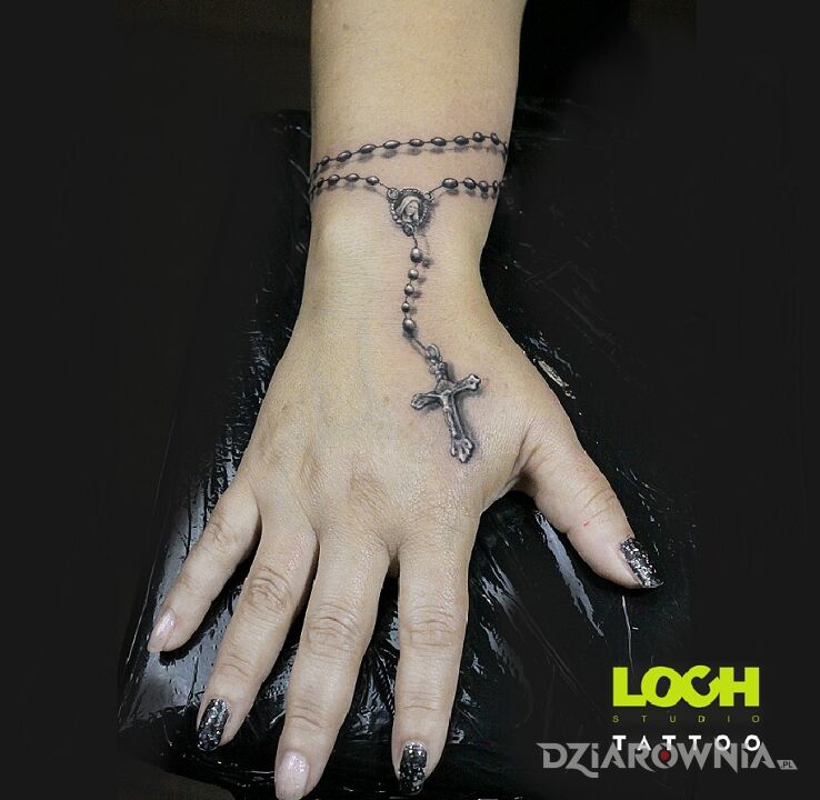 Tatuaż różaniec na ręku w motywie religijne i stylu realistyczne na dłoni