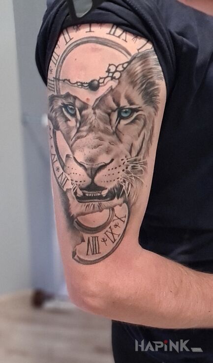 Tattoo Lew & zegar in zodiac signs motif and realistic style on the upper arm