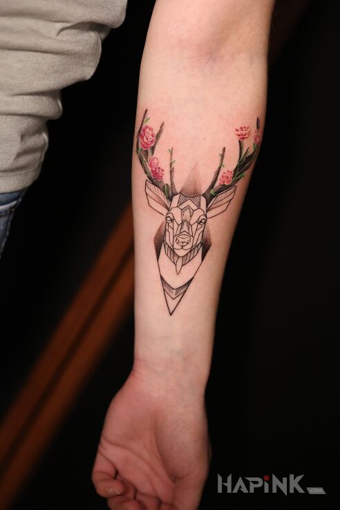 Tattoo Graficzny Jelonek in flowers motif and graphic / illustrative style on the forearm