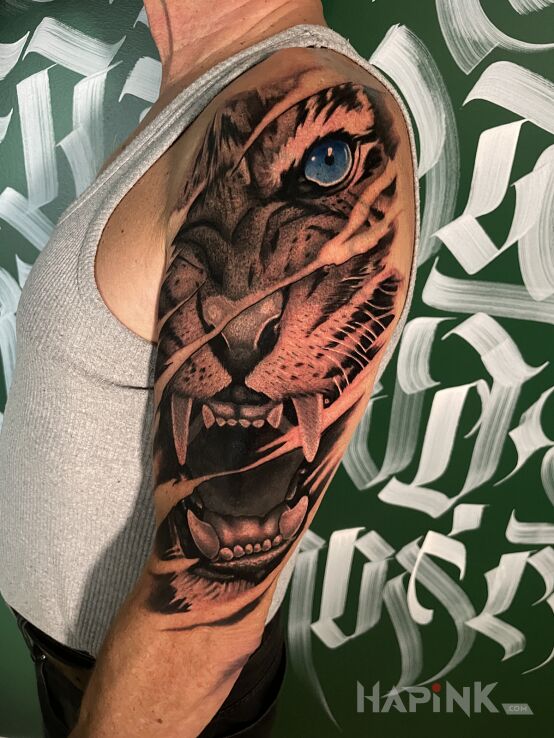 Tattoo Niebieskooki Tygrys in ripped skin motif and realistic style on the upper arm