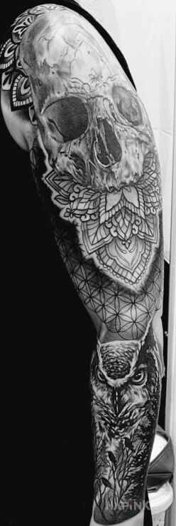 Tattoo Sowa, czaszka mandala in black and gray motif and geometric style On the arm