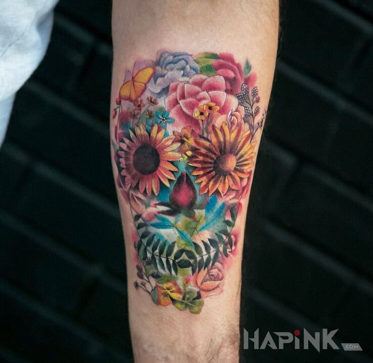 Tattoo Trochę inna czaszka in flowers motif on the forearm