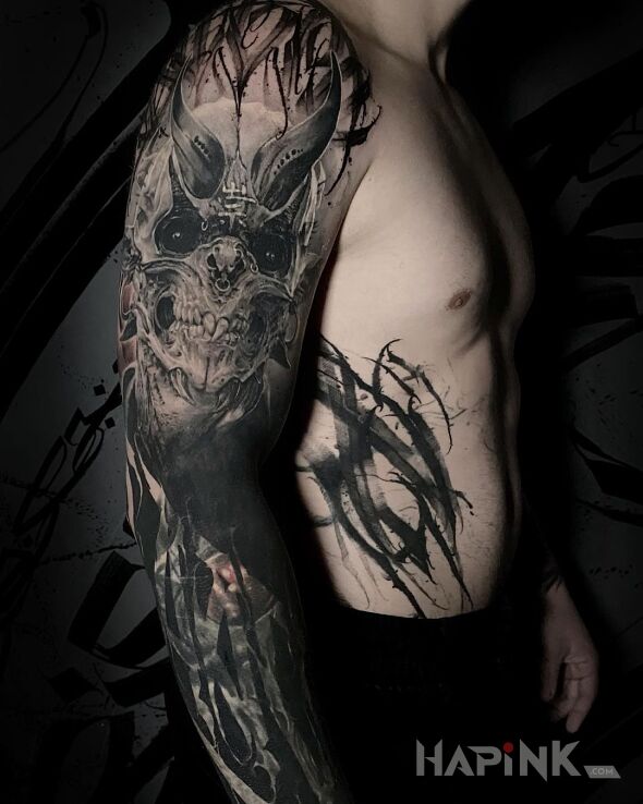 Tattoo Czarne oczy diabła in black and gray motif and blackwork / blackout style On the arm