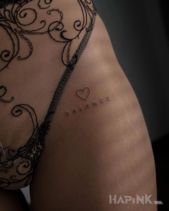 Tattoo Balans in lettering motif and minimalistic style on the hip