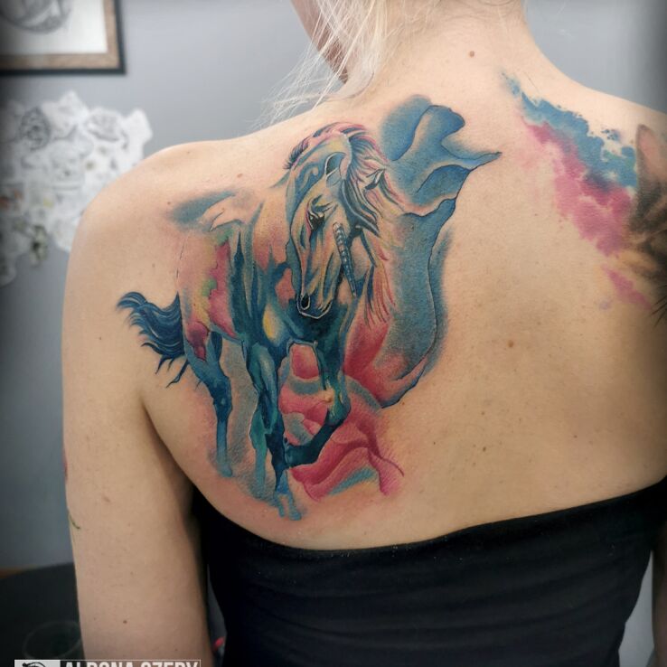 Tatuaż akwarelowy jednorożec w motywie natura i stylu watercolor na łopatkach