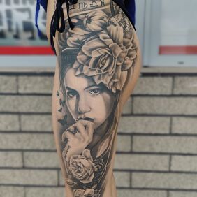 Tatuaż Kobieta z kwiatem we włosach na nodze motyw: twarze styl: realistyczne