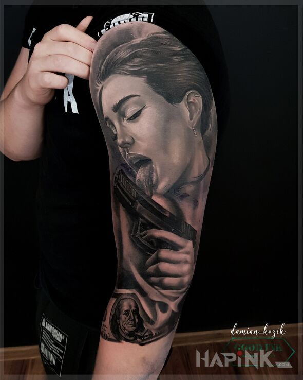 Tattoo Pistolet zamiast lizaka in black and gray motif and realistic style On the arm