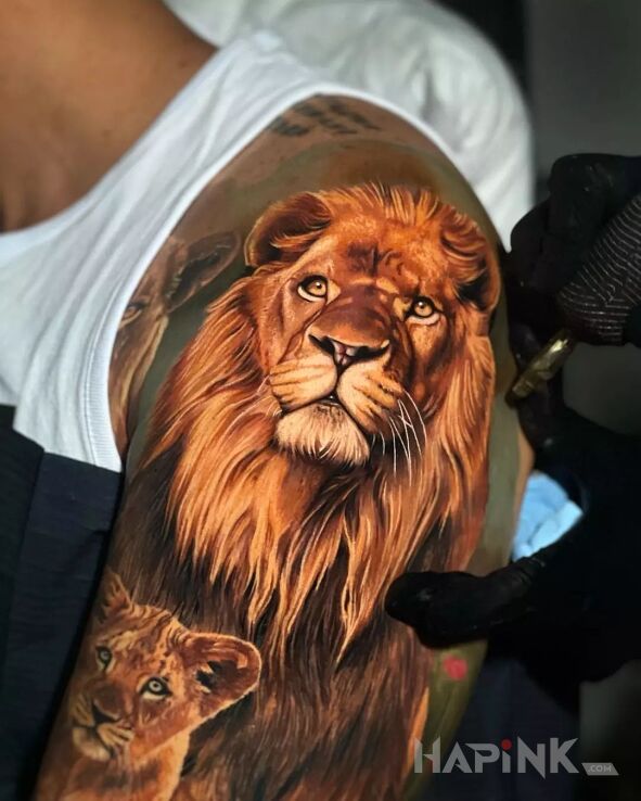 Tattoo Piękny lew in colorful motif and realistic style on the upper arm