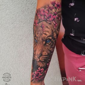 Tattoo Tiger in pink flowers On the arm motif: animals style: realistic