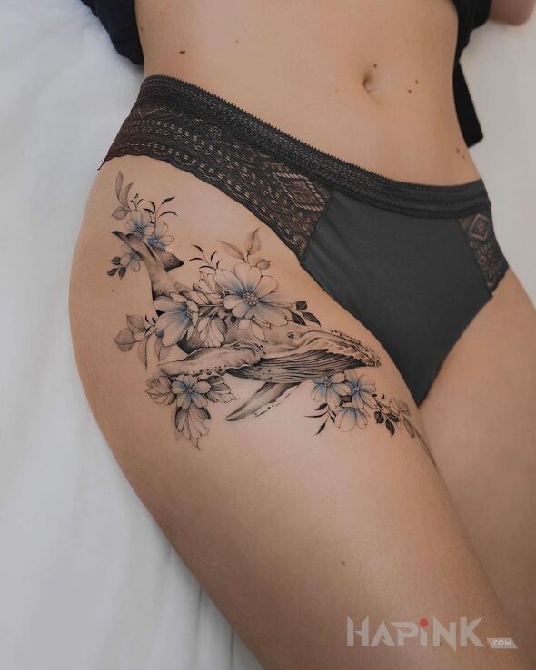 Tattoo Waleń płynący przez kwiaty in black and gray motif and graphic / illustrative style on the leg