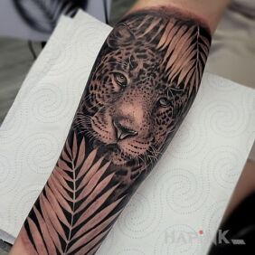 Tattoo Jaguar on the forearm motif: floral style: realistic