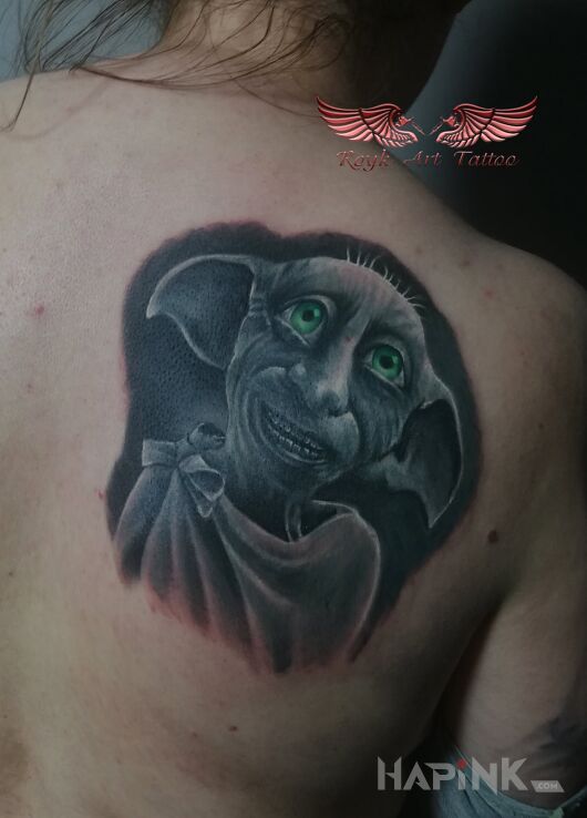 Tattoo Zgredek in faces motif and realistic style on the shoulder blades
