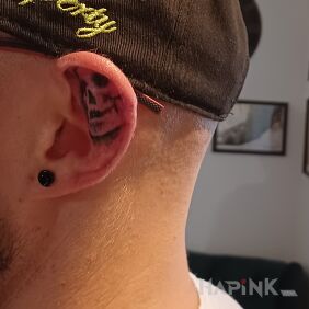 Tattoo Skull behind the ear motif: black and gray style: graphic / illustrative