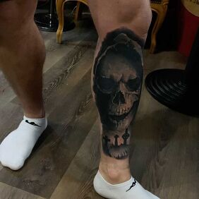 Tattoo Skull in a hood on the leg motif: black and gray style: realistic