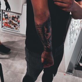Tattoo Woman with a finger on her lips On the arm motif: black and gray style: realistic