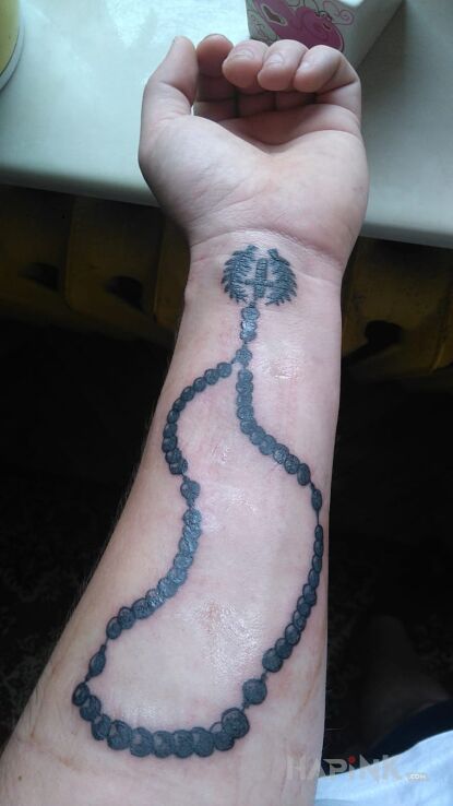 Tattoo Różaniec in religious motif on the forearm