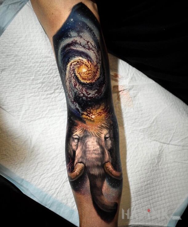 Tattoo Mamut in cosmos motif and realistic style on the forearm