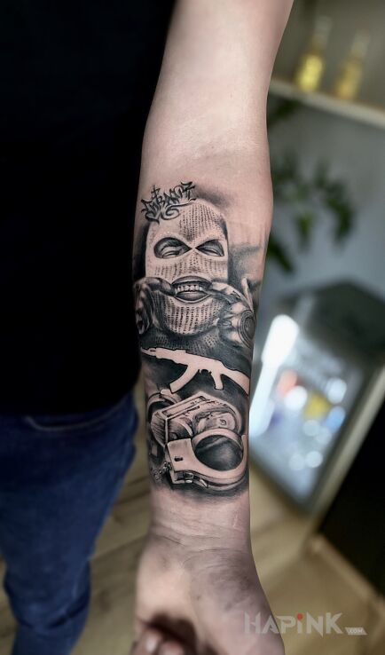 Tattoo Хулиган in faces motif and realistic style On the arm