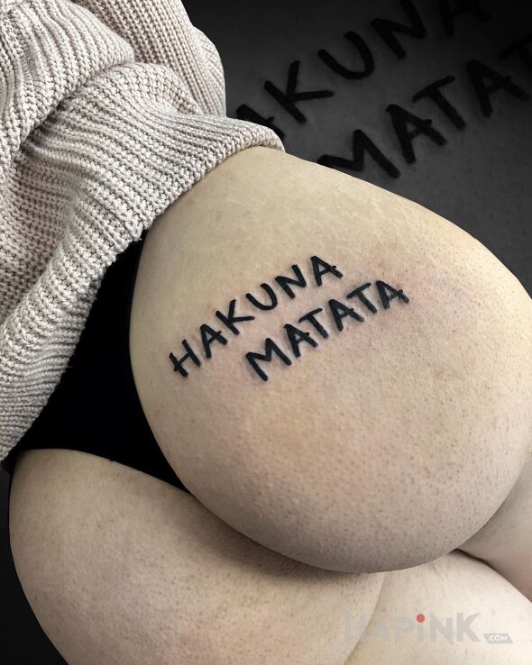 Tattoo Hakuna matata in lettering motif on the buttocks