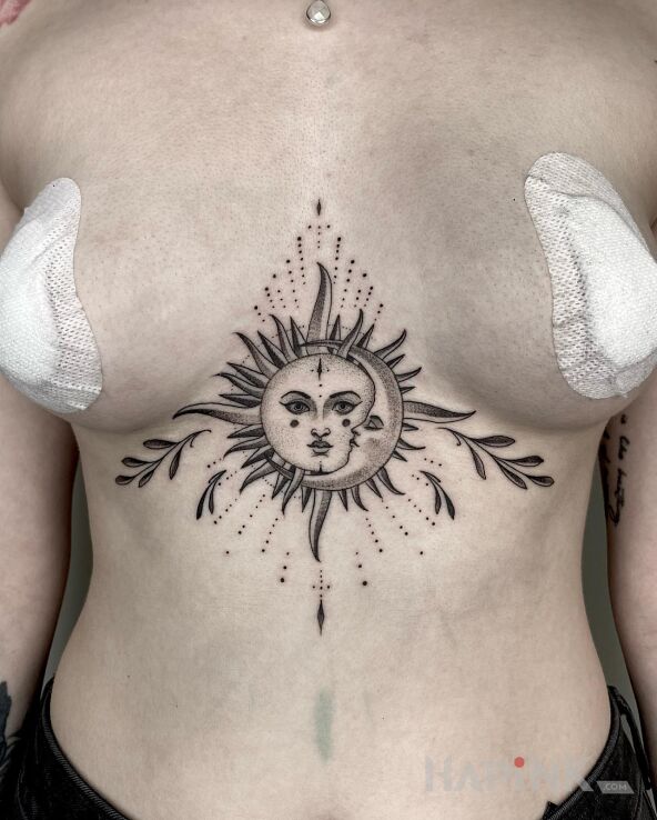 Tattoo Słońce / Księżyc in black and gray motif and graphic / illustrative style between the breasts