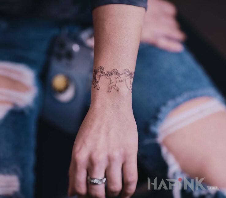Tattoo Korowod aniolkow in religious motif and graphic / illustrative style on the wrist