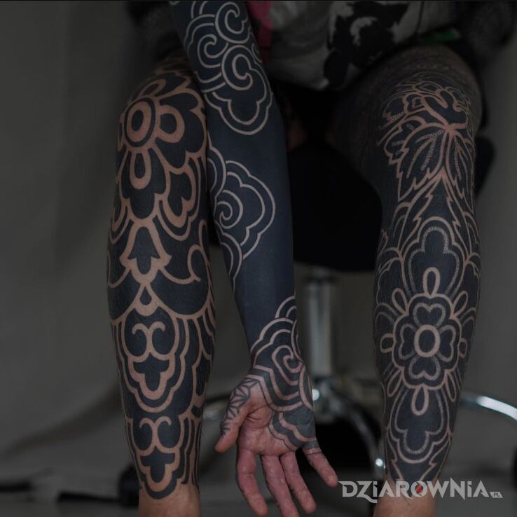 Tatuaż głęboka czerń w motywie nogawki i stylu blackwork / blackout na ręce