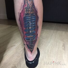 Tattoo Shock Absorber on the calf motif: ripped skin style: biomechanics