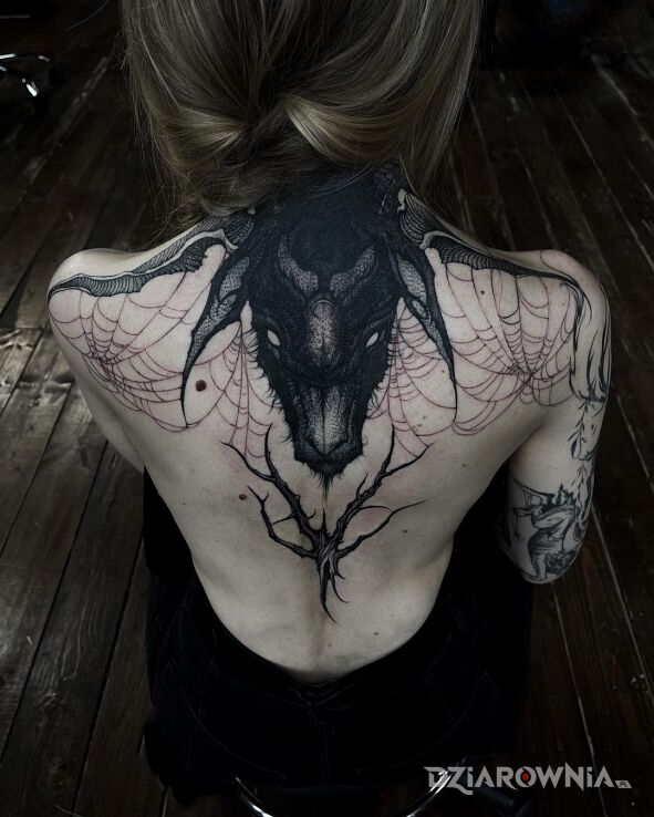 Tatuaż opetana koza w motywie mroczne i stylu blackwork / blackout na łopatkach