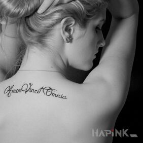 Tattoo Amor vincit omnia on the back motif: lettering