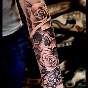 Tattoo Skull in roses On the arm motif: skulls style: realistic