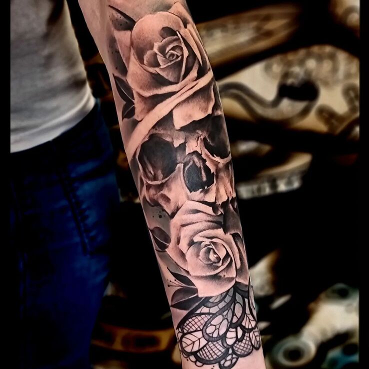 Tatuaż czaszka w różach w motywie florystyczne i stylu kontury / linework na przedramieniu