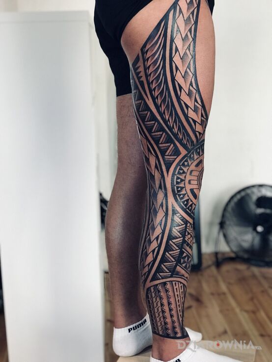 Tatuaż  w stylu polinezyjskim w motywie nogawki i stylu blackwork / blackout na łydce
